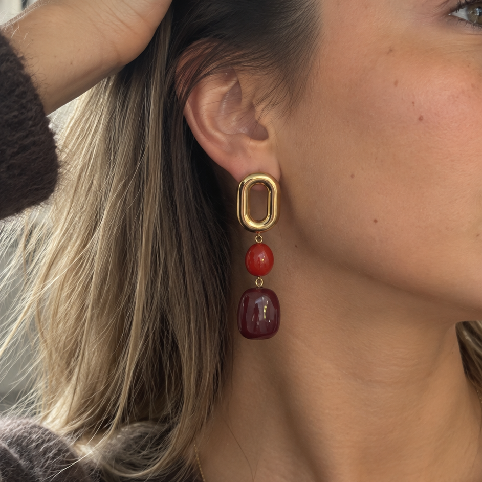 Boucles d'oreilles Anna portées — clou doré ovalé et perles rouge bordeaux